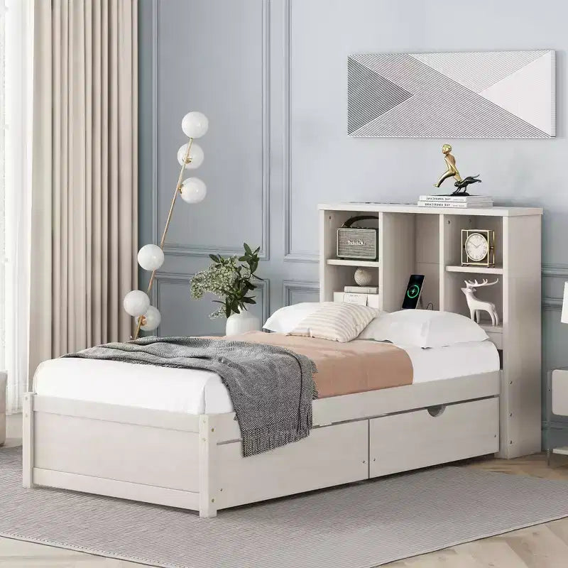 Estructura de cama matrimonial moderna de 87 pulgadas con cabecera de dos niveles estilo librero, puertos USB integrados y dos cajones. Acabado blanqueado